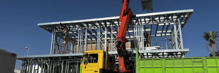 Ensamblaje de la estructura Steel Frame en obra con camión grúa