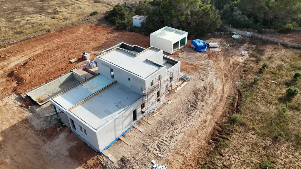 Módulo Steel Frame con envolvente cerrada junto a vivienda en construcción